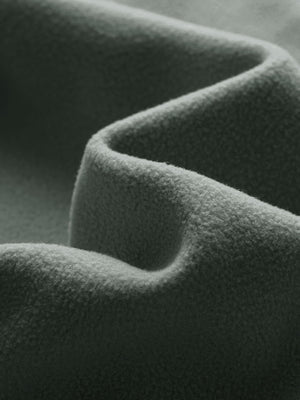 Close-up fabric detail of golf fleece winter puffer jackets, quilted texture and warm feel in agave green