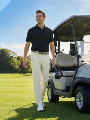 Model in beige water resistant everyday pants holding a golf club outdoors, full-body shot
