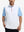 Upper body front view of model wearing white lightweight sleeveless quarter zip golf vest