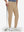 Front lower body shot of model wearing light khaki flat front golf joggers pants with belt loops