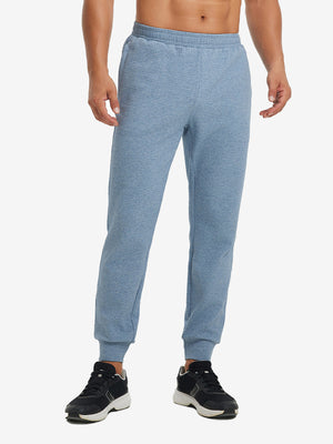 Front lower body view of model wearing soft sweatpants with 4 zipper pockets in blue heather