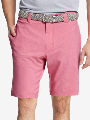 Front view of youth wearing pink Heather Performance Golf Shorts, showing fit and style
