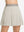 Front lower body shot of model wearing oyster gray women's moisture-wicking athletic tennis skirts