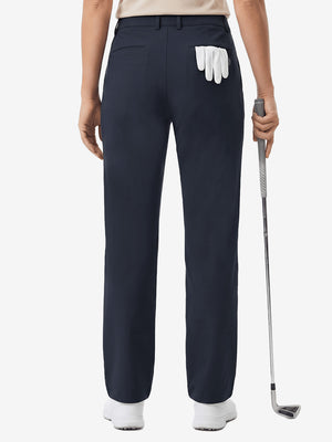 Back lower body shot of model wearing navy women's regular fit stretchy golf pants