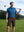 Model holding golf club wearing 4-way stretch performance solid shorts in clean dark brown