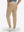 Back lower body shot of model wearing light khaki flat front golf joggers pants with belt loops