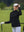 The model is wearing Women's Water-Resistant Stretch Fleece Lined Jacket black on the golf course.