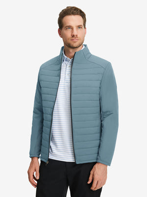 Front upper body shot of model wearing slate blue warm puffer winter golf jackets
