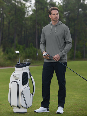 Model holding golf club beside golf bag in classic heather pullover hoodies with 2 pocket, grey melange