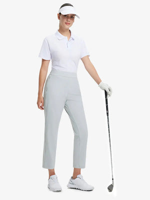 Full-body front view wearing golf hat and holding club in GLACIER GREY Women's 7/8 Ankle Golf Track Pants.