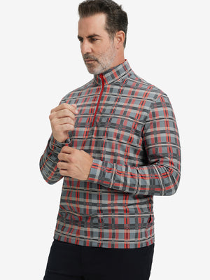 Front upper body view of model standing in red/black/white plaid full print quarter zip pullover, relaxed look.