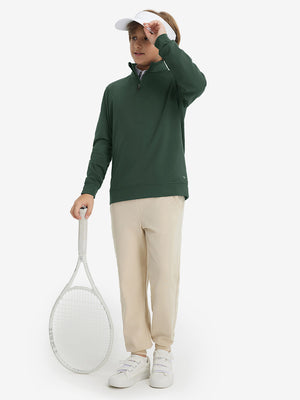 Model wearing a cap and holding a tennis racket, youth winter micro-fleece quarter zip pullover in forest green