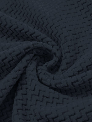 Fabric close-up of warm stretchy quarter zip with pocket, smooth knit texture and flexible feel in navy