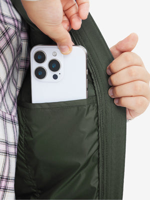 Close-up of boys full-zip fleece-lined puffer vest pocket holding a phone, practical detail in army green