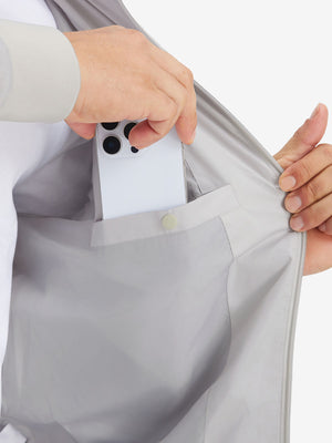 Hand placing iPhone into inner pocket of casual windproof bomber jacket in glacier grey
