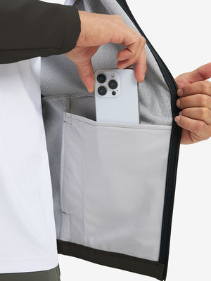 Hand placing an iPhone into pocket of water-resistant heat-tech softshell winter jacket with hood.