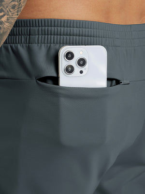 Back pocket detail of Water Resistant Comfy Fleece Golf Joggers in sky blue, holding smartphone