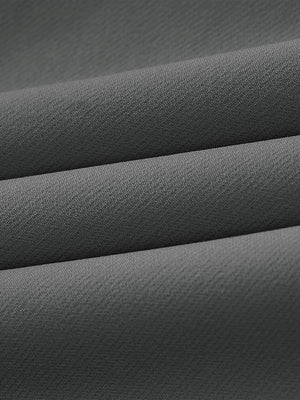 Close-up of wrinkle-resistant, sun-protective fabric on water-resistant golf stretch nylon pants in dark grey.