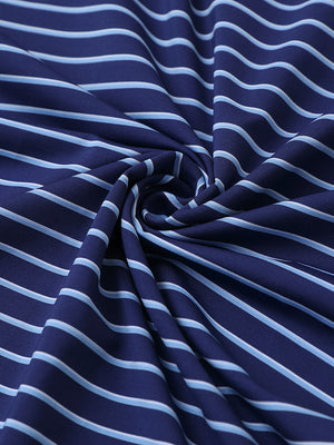 Close-up fabric view of youth performance golf polos, smooth texture with breathable navy/sky blue stripe finish