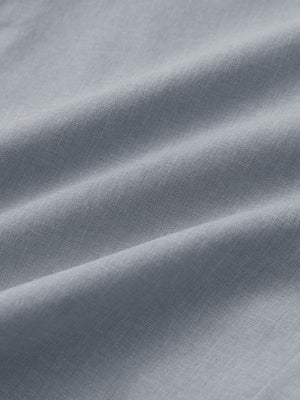 Close-up of light grey heather performance golf shorts fabric showing breathable texture.