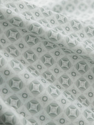 Close-up of gray geometric stretch printed collarless henley golf shirts, showcasing texture and print details.