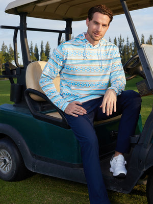 Model sitting in a golf cart outdoors, wearing trendy print fleece hoodies in ethnic