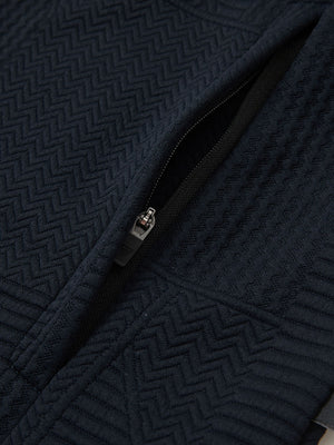 Close-up of jacket pocket showing fine stitching and insulation detail, textured insulated winter jacket, navy.