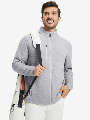 Full body shot, model carrying golf bag in textured insulated winter jacket, active outdoor style, light grey heather.