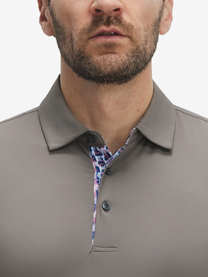 Close-up of a model wearing the light brown everyday classic solid polo, focusing on the collar and chest area