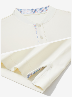 Detail of cream moisture-wicking short sleeve henley shirt showing collar and hem vent construction.