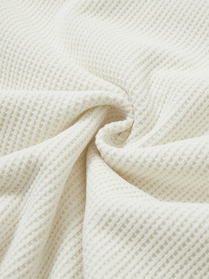 Close-up of fabric on textured insulated winter jacket, showing texture and finish in beige.